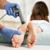 patient getting shockwave therapy on her feet