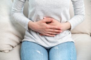 woman holding her stomach with digestive pain