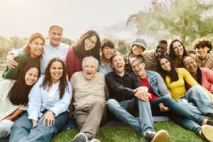 multiple generations of a family smiling and sitting at the park